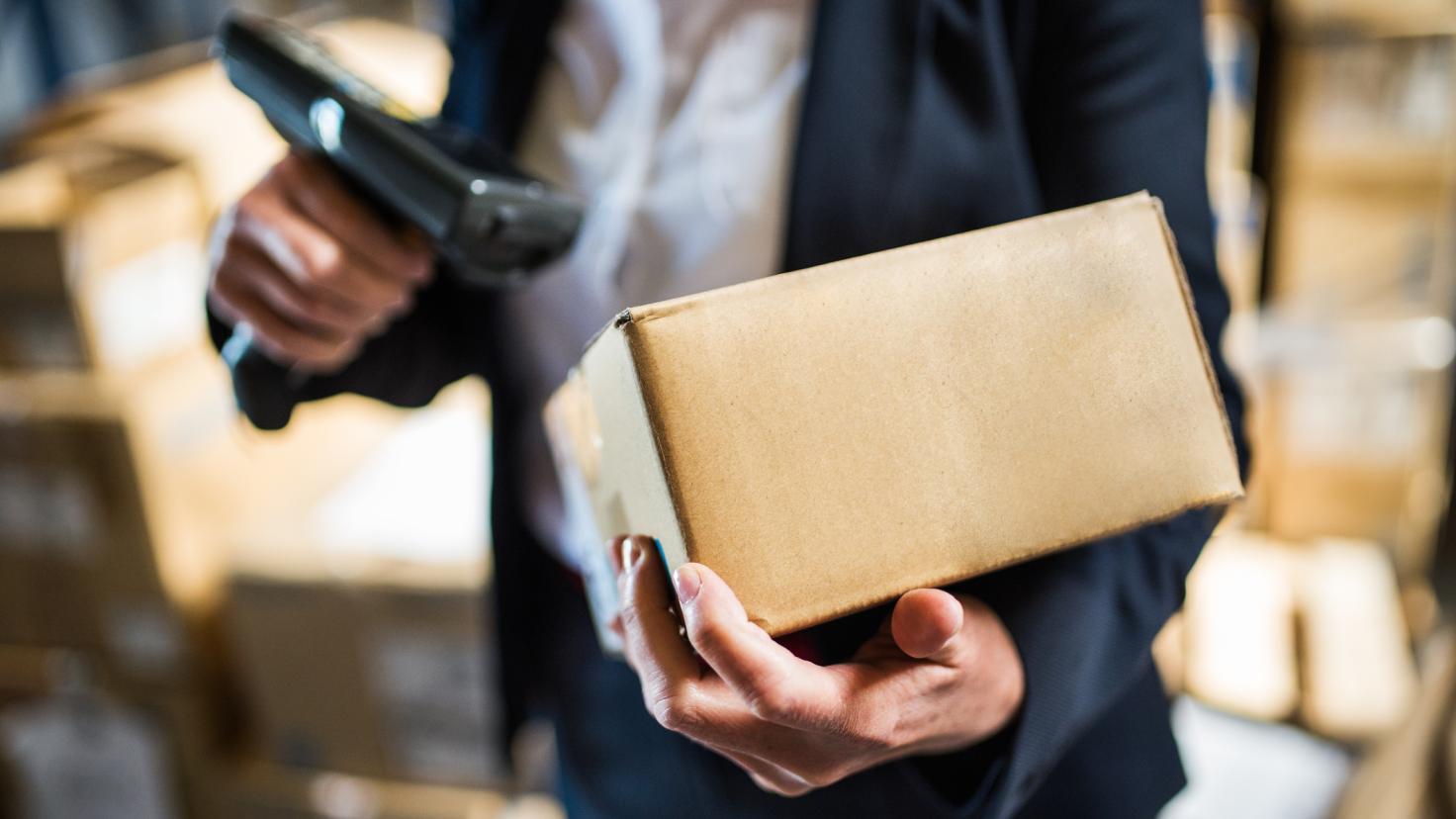 A man scans the barcode on a package